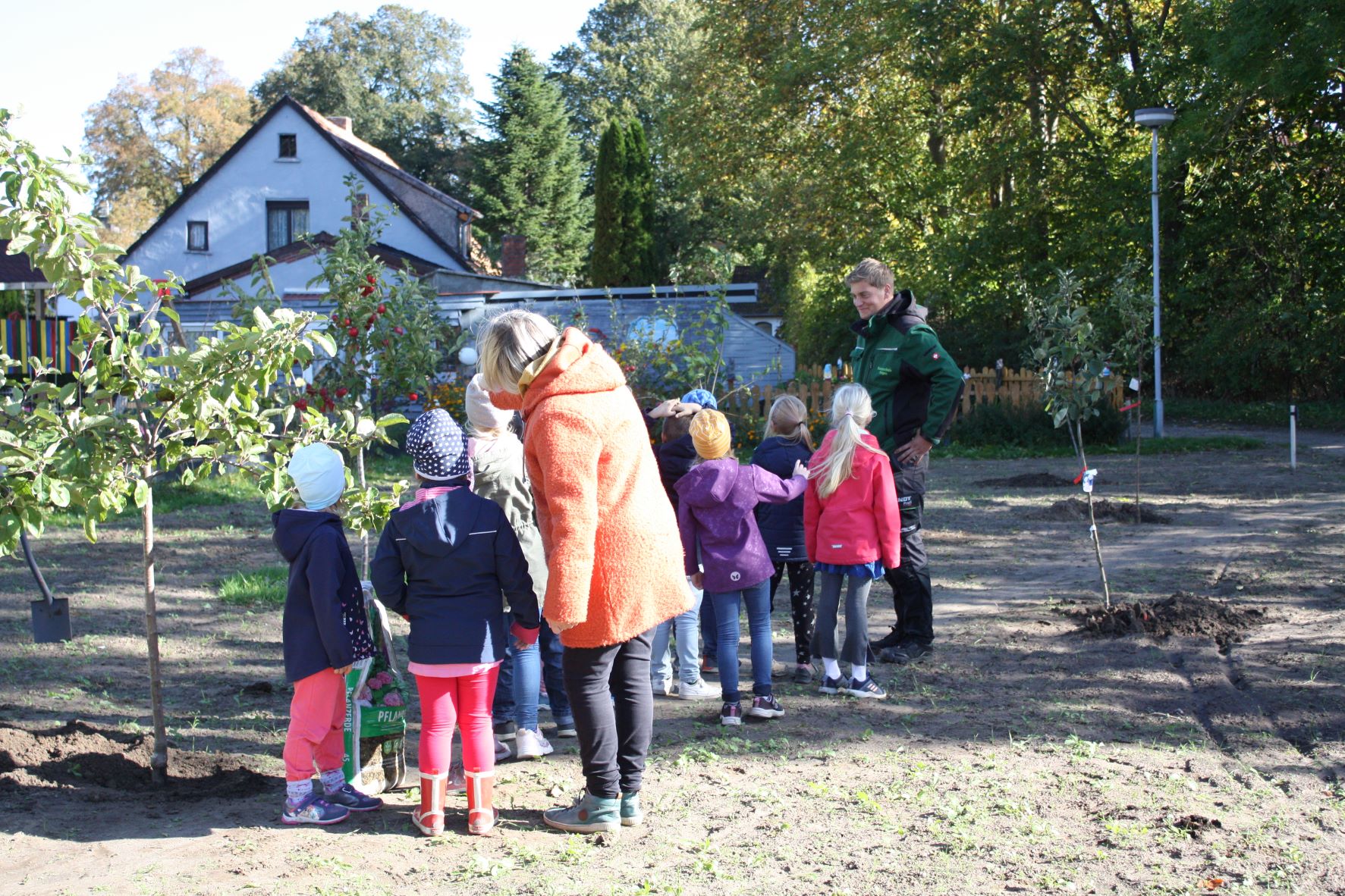 Florian Wolf (Inh. Baumschule Rügen) erklärt den Grundschülern, was bei der Pflanzung von Bäumen zu beachten ist und warum Streuobstwiesen so wertvoll für Mensch und Natur sind